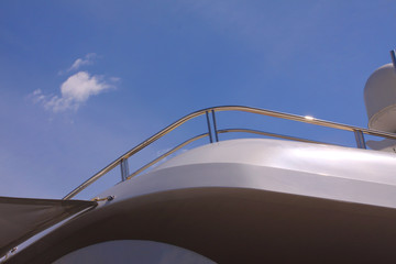 Modern luxury yacht details with stainless steel yacht railing - Minimalistic lines in sunny weather with a deep blue sky - copy space for writing