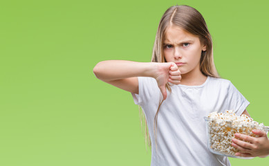 Young beautiful girl eating popcorn snack isolated background with angry face, negative sign showing dislike with thumbs down, rejection concept