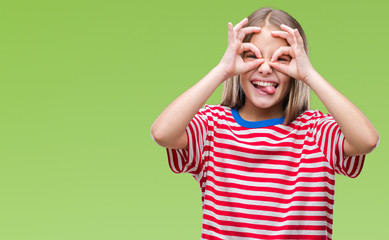 Young beautiful girl over isolated background doing ok gesture like binoculars sticking tongue out,...