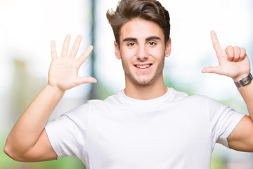Young handsome man wearing white t-shirt over isolated background showing and pointing up with fingers number seven while smiling confident and happy.