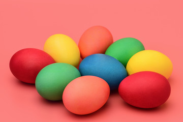 Colorful Easter eggs lie on a pink background. Horizontal photography.