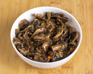 Fried mushrooms in a plate on the table.