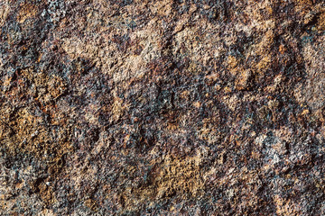 Rough rustic rocky wall texture. Brown corroded and cracked stone background.