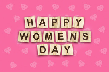 Happy women's day, the inscription consists of the alphabet on wooden cubes. Pink background.