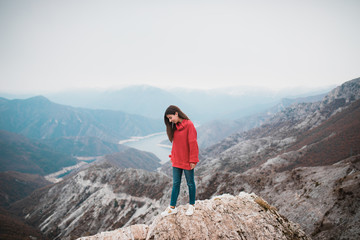 Beautiful Young Girl in a cosy red sweater on Mountain top