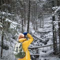 Fototapeta na wymiar The photographer in winter forest in mountains