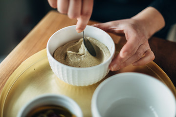 Fototapeta na wymiar Chef serving hummus into a small bowl