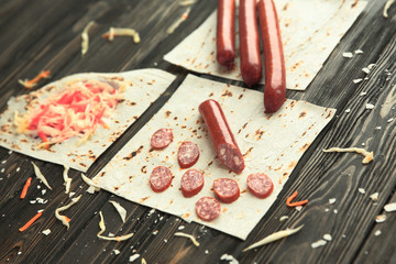 sausages, pickled cabbage and pita bread on wooden background