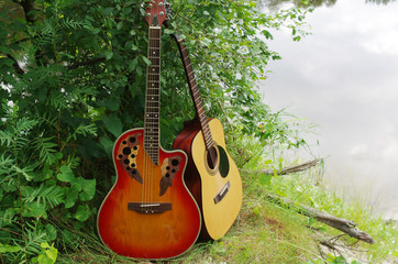 Two acoustic guitars on the river bank