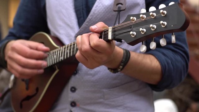 Close up of male play on the mandolin