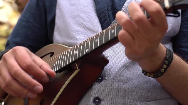 Close up of male play on the mandolin