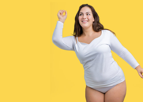 Beautiful plus size young overwight woman wearing white underwear over isolated background Dancing happy and cheerful, smiling moving casual and confident listening to music