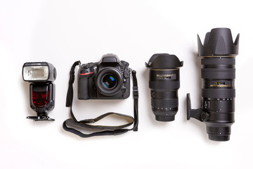 SLR camera, lenses and flash on white background