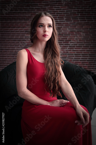 Stylish Young Woman In Red Dress Sitting In Big Round Chair