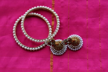 Indian decorations for dancing: bracelets, earrings for dancing bharatanatyam or kathak. Fabric background.