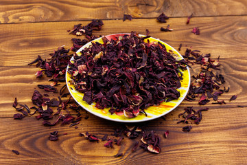 Dried hibiscus (carcade, roselle) on wooden table
