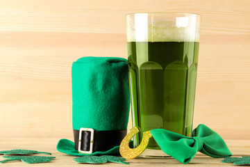 St.Patrick 's Day. celebration. green leprechaun hat and green beer, bow tie, coins and clover on a...