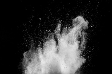 White powder explosion isolated on black background. White dust particles splash.Color Holi Festival.