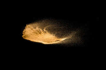 Plakat Yellow sand explosion isolated on black background. Abstract sand cloud.