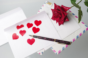 Love message Envelope, pen, red hearts and a rose.