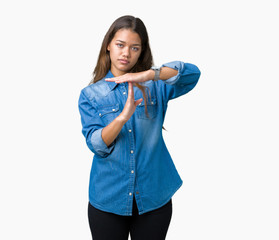 Young beautiful brunette woman wearing blue denim shirt over isolated background Doing time out gesture with hands, frustrated and serious face