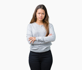 Young beautiful brunette woman wearing sweater over isolated background skeptic and nervous, disapproving expression on face with crossed arms. Negative person.