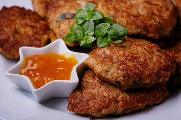 Homemade cutlets from minced fish with sauce. Close up