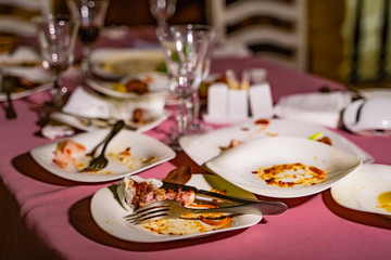 The leftover food and dirty dishes on the restaurant table.