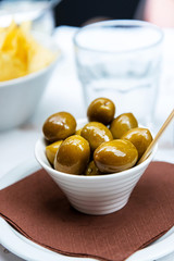 green olives in white bowl on table