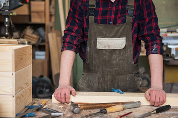Carpenter working with a chisel and hammer in a wooden workshop