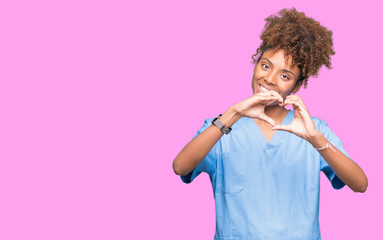 Young african american doctor woman over isolated background smiling in love showing heart symbol...