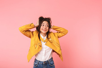 Beautiful young girl posing isolated over pink background.