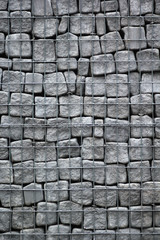 Grey stones behind metal grate, abstract vertical background
