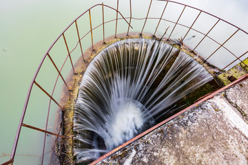A small indusrial waterfall of the lake to adjust the water level with a view from the bridge