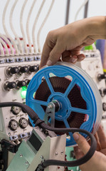 worker corrects the soldering device on the embroidery machine