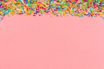 greeting card of colorful sprinkles over pink background, festive invitation for Valentines day, birthday, holiday and party time