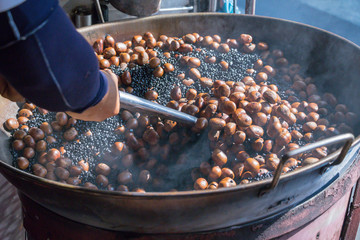 Closeup roasting chestnuts at street market in Bangkok,Thailand.