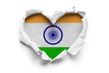 Heart shaped hole torn through paper, showing satin texture of flag of India. Isolated on white...