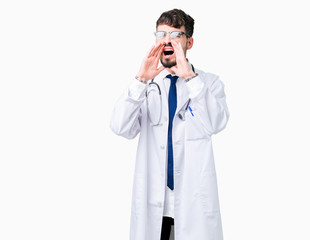 Young doctor man wearing hospital coat over isolated background Shouting angry out loud with hands over mouth