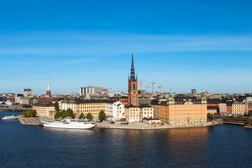 Fototapeta na wymiar View onto Gamla Stan with Riddarholmskyrkan and a white large ship as seen from Södermalm during summer (Stockholm, Sweden, Europe)