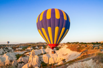 Fototapeta na wymiar Cappadocia Turkey. Balloons at the sunrise fly over the beautiful cave.