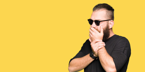 Young hipster man wearing sunglasses looking stressed and nervous with hands on mouth biting nails. Anxiety problem.