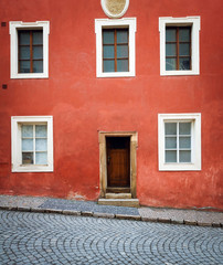Old building front with red textured facade in the old european city. Beautiful architecture.