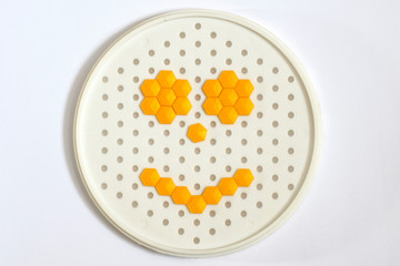 Yellow smiley from mosaic on a white background