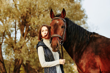 Fototapeta premium Woman with her horse at sunset, autumn outdoors scene