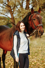 Woman with her horse at sunset, autumn outdoors scene