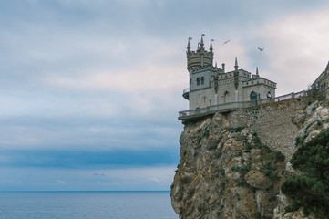 Fototapeta na wymiar Castle Swallow's Nest on a rock at Black Sea, Crimea, Russia. It is a symbol and tourist attraction of Crimea. Scenic panoramic view of the Crimea southern coast. Architecture and nature of Crimea.