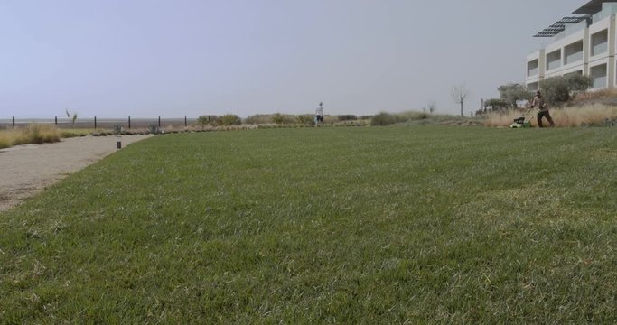 Timelapse gardener operating scarifying machine in grass lawn