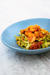 Cooked pasta with peeled shrimp, coconut milk sauce and broccoli
