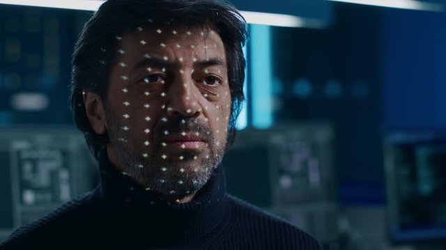 Biometric Facial Recognition Scanning Proccess. Man Getting Identified by Hardware Scanning Facial Feautures with Moving Light. Futuristic Concept Shot in High Tech Laboratory